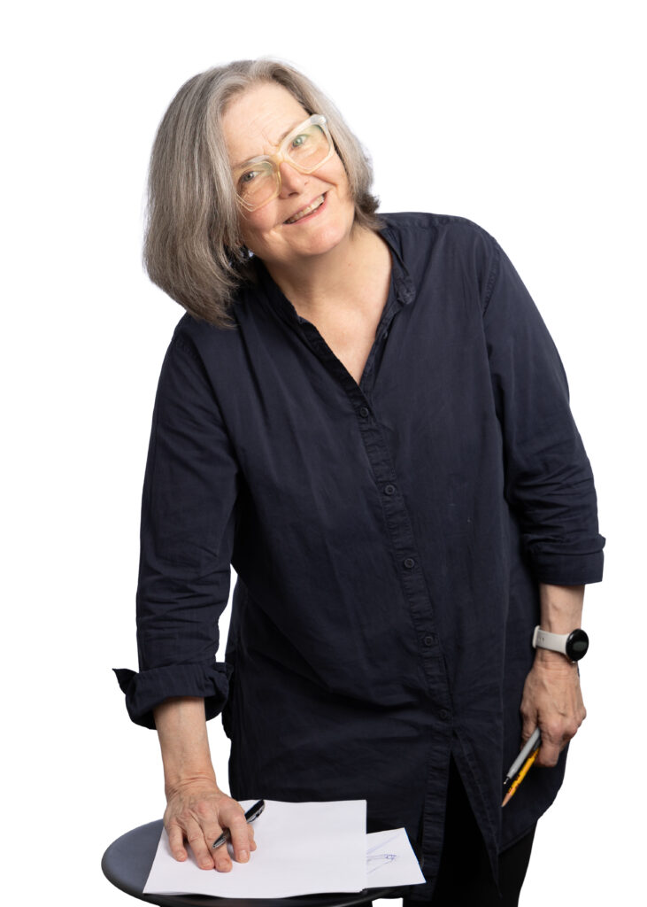 Courtroom illustrator Elizabeth Williams smiling with her sketchpad and pencil inside David Beyda Studio in Manhattan.